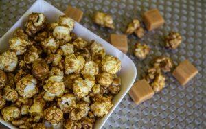 Caramel popcorn served in a white bowl, ideal for Christmas sweets and treats enthusiasts.