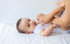 A woman is holding a baby, discussing primary teeth and their eventual replacement with permanent teeth.