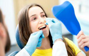 A woman is having her teeth examined by a dental hygienist during Dental Hygienists' Week.