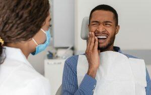 A man in a dentist's chair learning about oral hygiene mistakes to avoid.